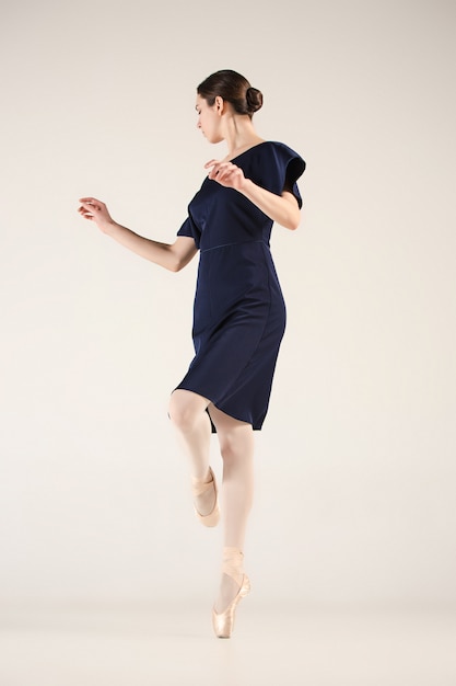 Młoda i niezwykle piękna baletnica tańczy w niebieskim studio