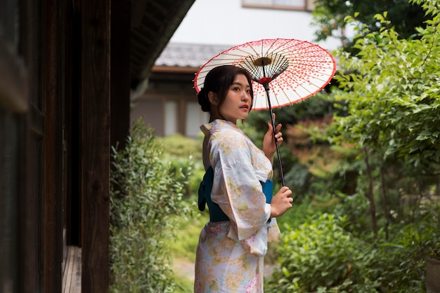 Młoda Japonka ubrana w kimono i trzymająca parasolkę