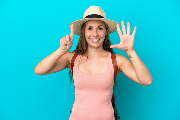 Młoda kaukaska kobieta w letnie wakacje na białym tle na niebieskim tle, licząc sześć palcami