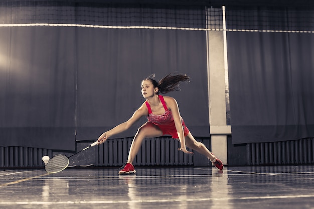 Młoda kobieta bawić się badminton przy gym