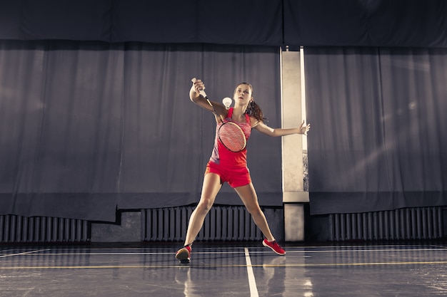 Młoda kobieta bawić się badminton przy gym