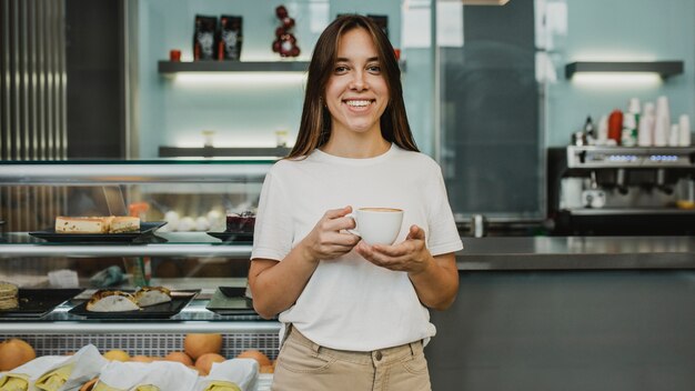 Młoda kobieta, ciesząc się filiżanką kawy