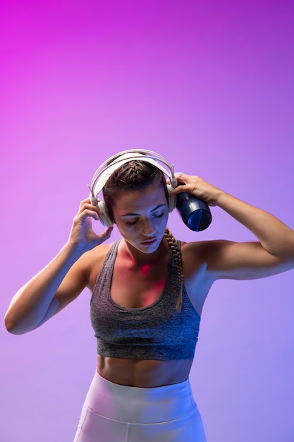 Bezpłatne zdjęcie młoda kobieta ćwiczy ze słuchawkami na słuchawkach