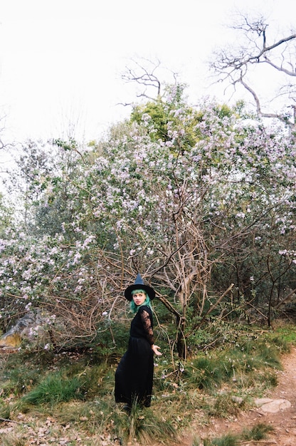 Bezpłatne zdjęcie młoda kobieta czarownica na drzewie