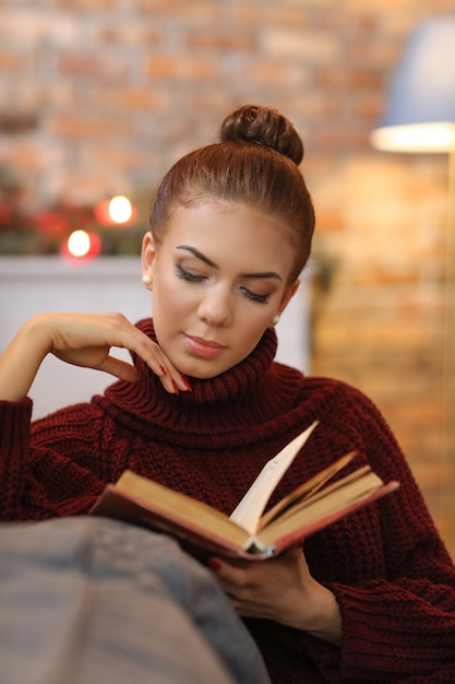 Bezpłatne zdjęcie młoda kobieta czyta książkę na kanapie