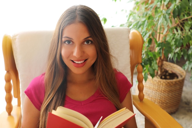 Młoda kobieta czyta książkę w domu