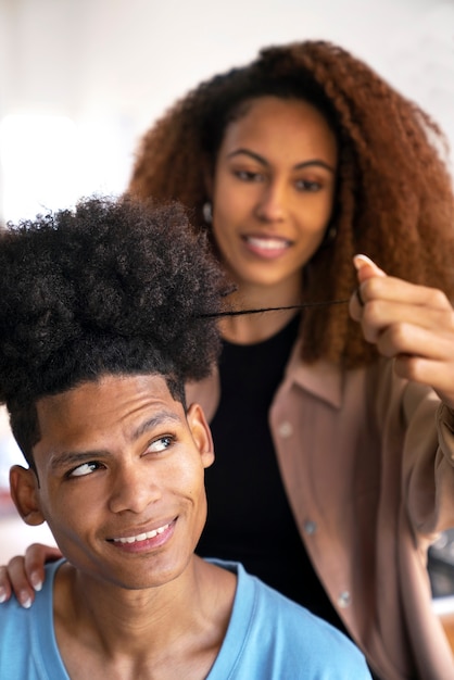 Młoda kobieta dbająca o włosy afro chłopca