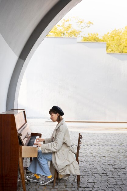 Młoda kobieta gra na pianinie na zewnątrz z miejscem na kopię