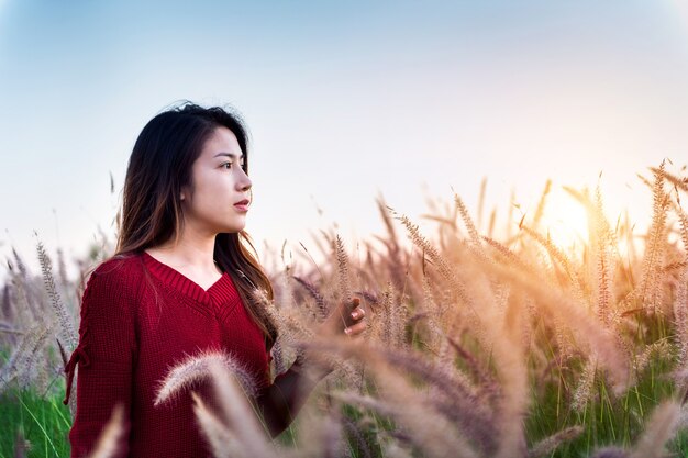 Młoda kobieta i łąka o zachodzie słońca.