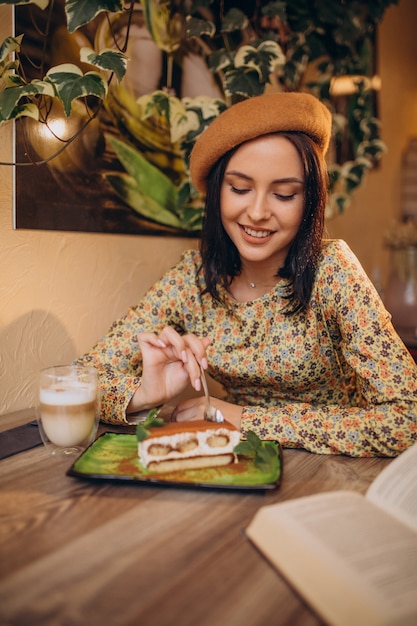 Bezpłatne zdjęcie młoda kobieta jedzenie pyszne tiramisu w kawiarni