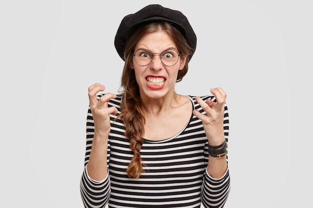 Bezpłatne zdjęcie młoda kobieta jest ubranym pasiastą koszulę i beret