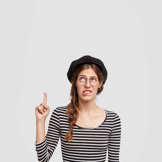 Młoda kobieta jest ubranym pasiastą koszulę i beret