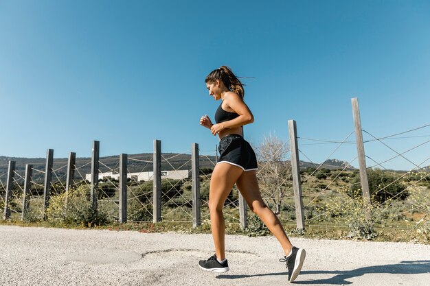 Młoda kobieta jogging wzdłuż wiejskiej drogi