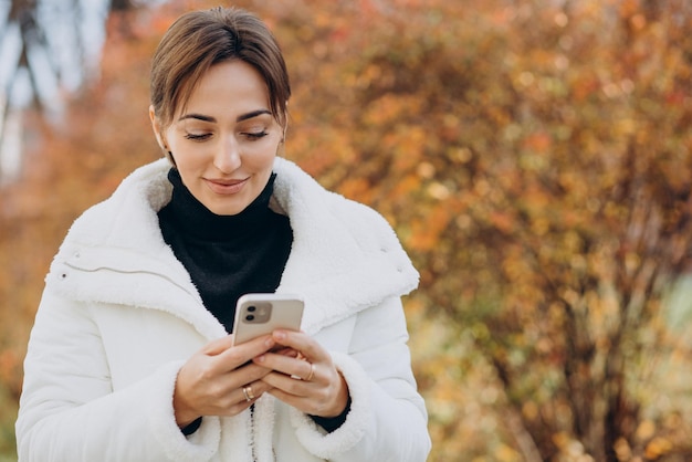 Młoda Kobieta Korzystająca Z Telefonu Na Zewnątrz