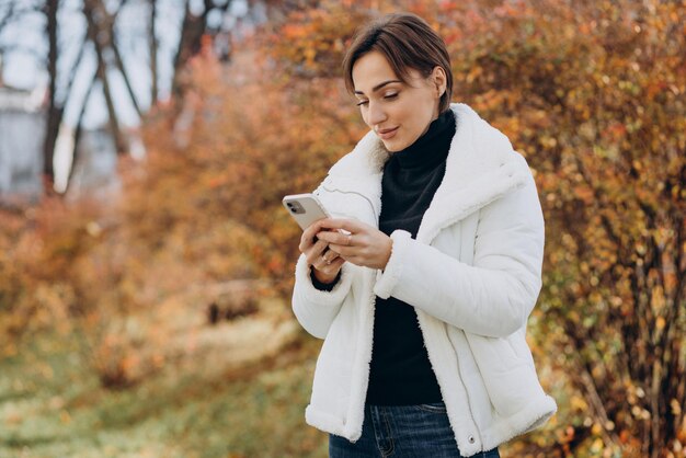 Młoda kobieta korzystająca z telefonu na zewnątrz