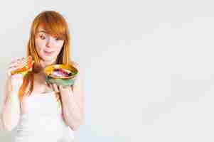 Bezpłatne zdjęcie młoda kobieta liże jej jęzor podczas gdy patrzejący oatmeal rzucać kulą