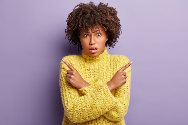 Młoda kobieta ma na sobie żółty sweter z fryzurą Afro