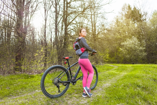 Bezpłatne zdjęcie młoda kobieta na wycieczce z jej bicyklem