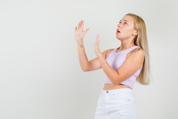 Młoda kobieta nie pokazuje gestu, patrząc w podkoszulek