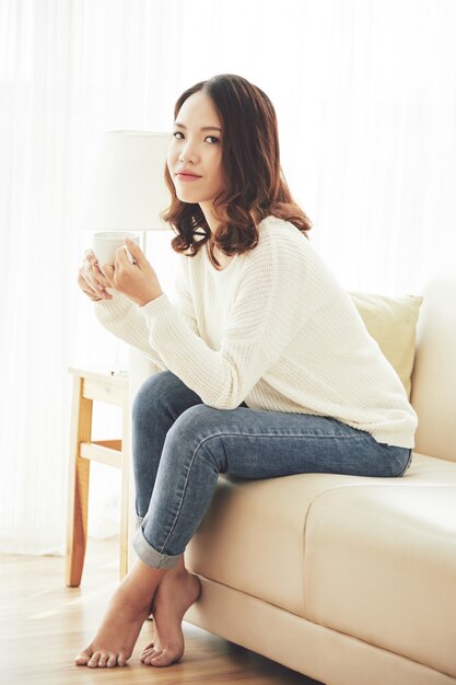 Młoda kobieta odpoczywa z filiżanką herbata