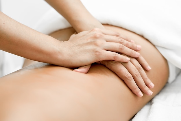 Bezpłatne zdjęcie młoda kobieta otrzymania masaż kręgosłupa w centrum spa.