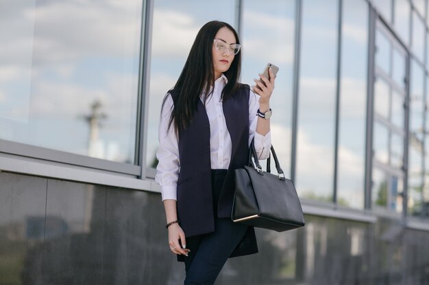 Młoda kobieta, patrząc na telefon komórkowy