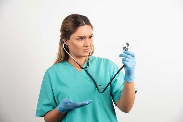 Młoda kobieta pielęgniarka pozuje ze stetoskopem.