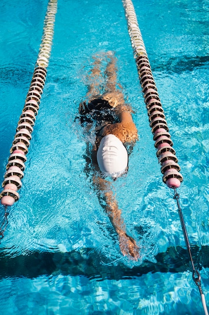Młoda kobieta pływa w basenie.