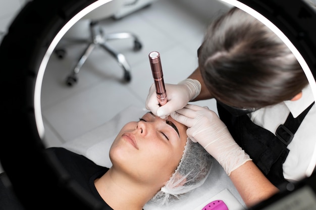 Młoda kobieta poddawana zabiegowi microblading