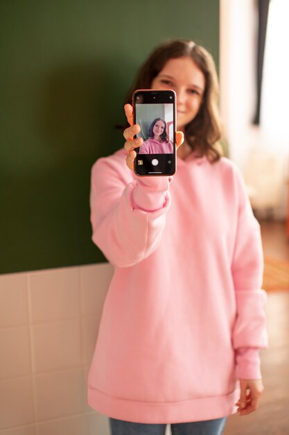 Młoda kobieta podłączona do swojego smartfona