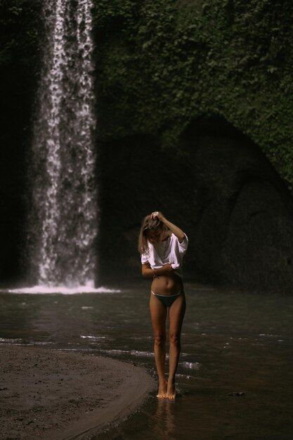 młoda kobieta podróżuje po wyspie robiąc zdjęcia przy wodospadzie