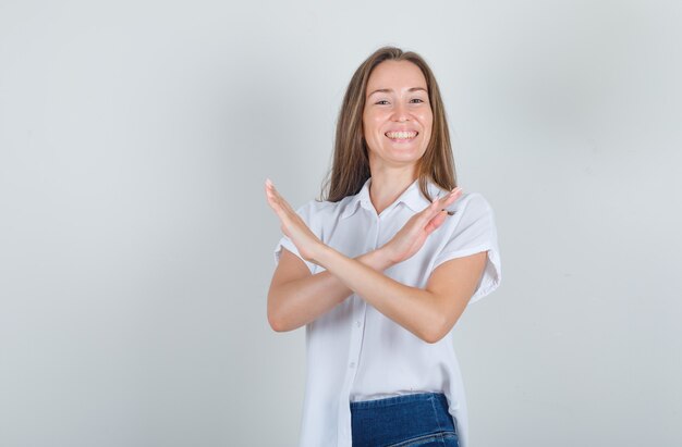 Młoda kobieta pokazuje wystarczająco dużo gestów w białej koszuli