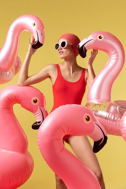 Młoda kobieta pozuje z pierścieniem pływackim Flamingo