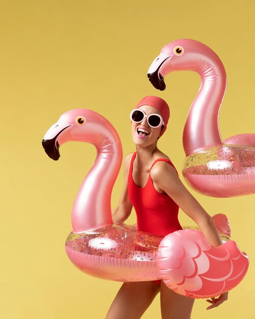 Młoda kobieta pozuje z pierścieniem pływackim Flamingo