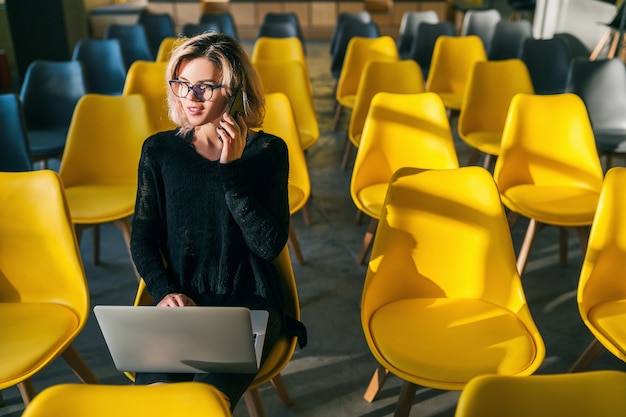 Bezpłatne zdjęcie młoda kobieta pracuje na laptopie w biurze współpracującym