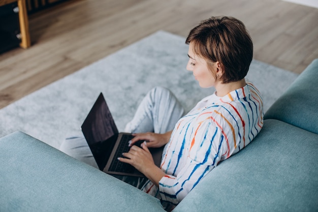 Młoda kobieta pracuje na laptopie w domu