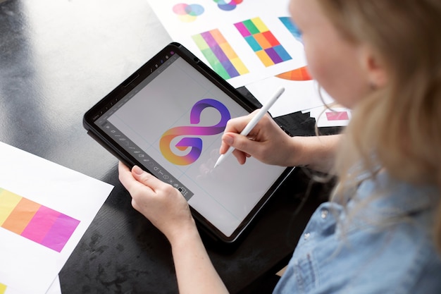 Młoda kobieta projektantka logo pracująca na tablecie graficznym