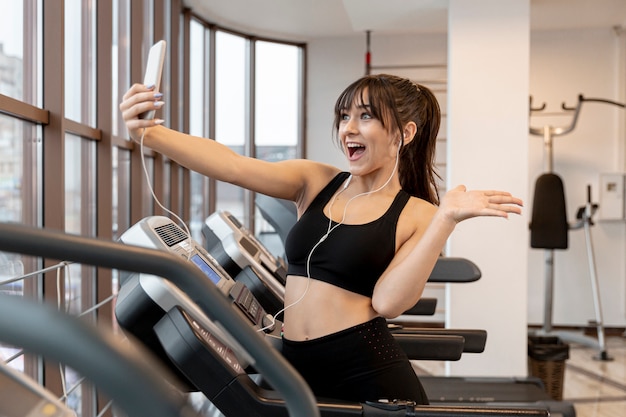 Młoda kobieta przy gym bierze selfie