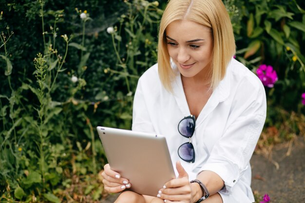 Młoda kobieta przy użyciu komputera przenośnego i inteligentnego telefonu. Beautiful girl studenta pracy na laptopie na wolnym powietrzu