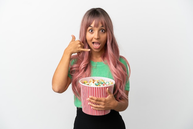 Młoda Kobieta Rasy Mieszanej Z Różowymi Włosami Jedzenie Popcornu Na Białym Tle Co Telefon Gest. Oddzwoń Do Mnie Znak Premium Zdjęcia
