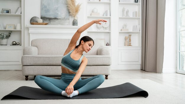 Młoda kobieta robi swój trening w domu na macie fitness