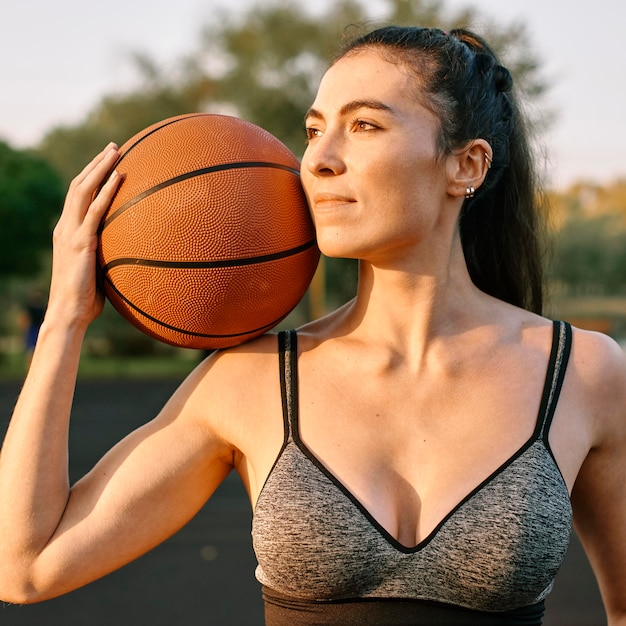 Bezpłatne zdjęcie młoda kobieta sama gra w koszykówkę