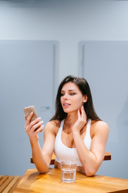 Młoda kobieta siedzi smartphone i używa po trenować