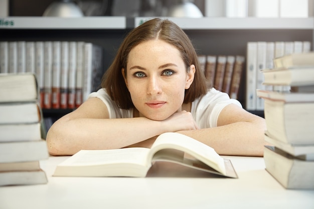 Młoda kobieta siedzi w bibliotece