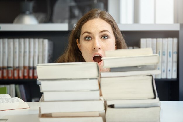 Młoda kobieta siedzi w bibliotece