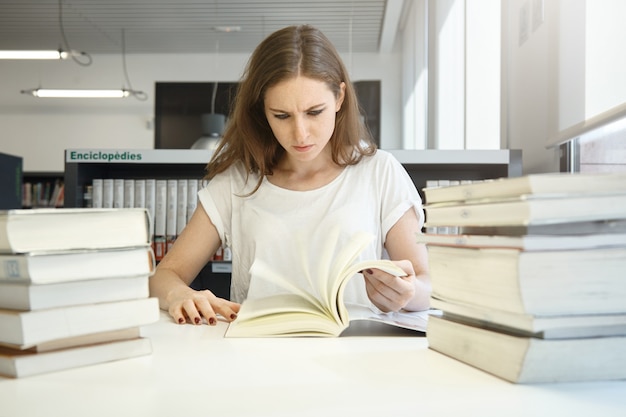 Młoda Kobieta Siedzi W Bibliotece