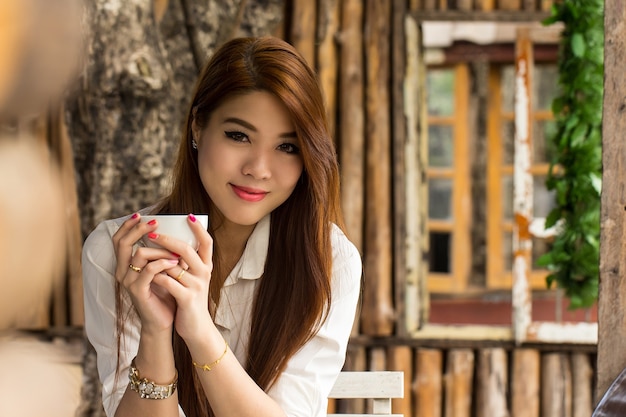 Młoda Kobieta Siedzi W Kawiarni Do Sprawdzenia I Wyszukiwania W Internecie Na Zewnątrz. Premium Zdjęcia