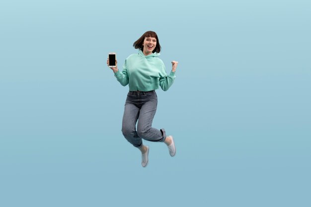 Młoda kobieta skoki na białym tle na niebiesko