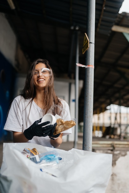 Młoda kobieta sortuje śmieci. Pojęcie recyklingu. Zero marnowania