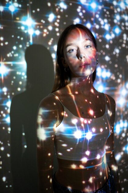 Młoda kobieta stojąca w projekcji tekstury wszechświata